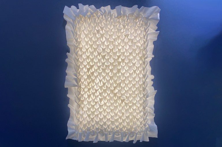 Glowing white fabric with a complex puckered stitch technique